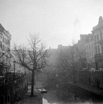 845479 Gezicht over de Oudegracht te Utrecht op de Bakkerbrug, in de mist.
